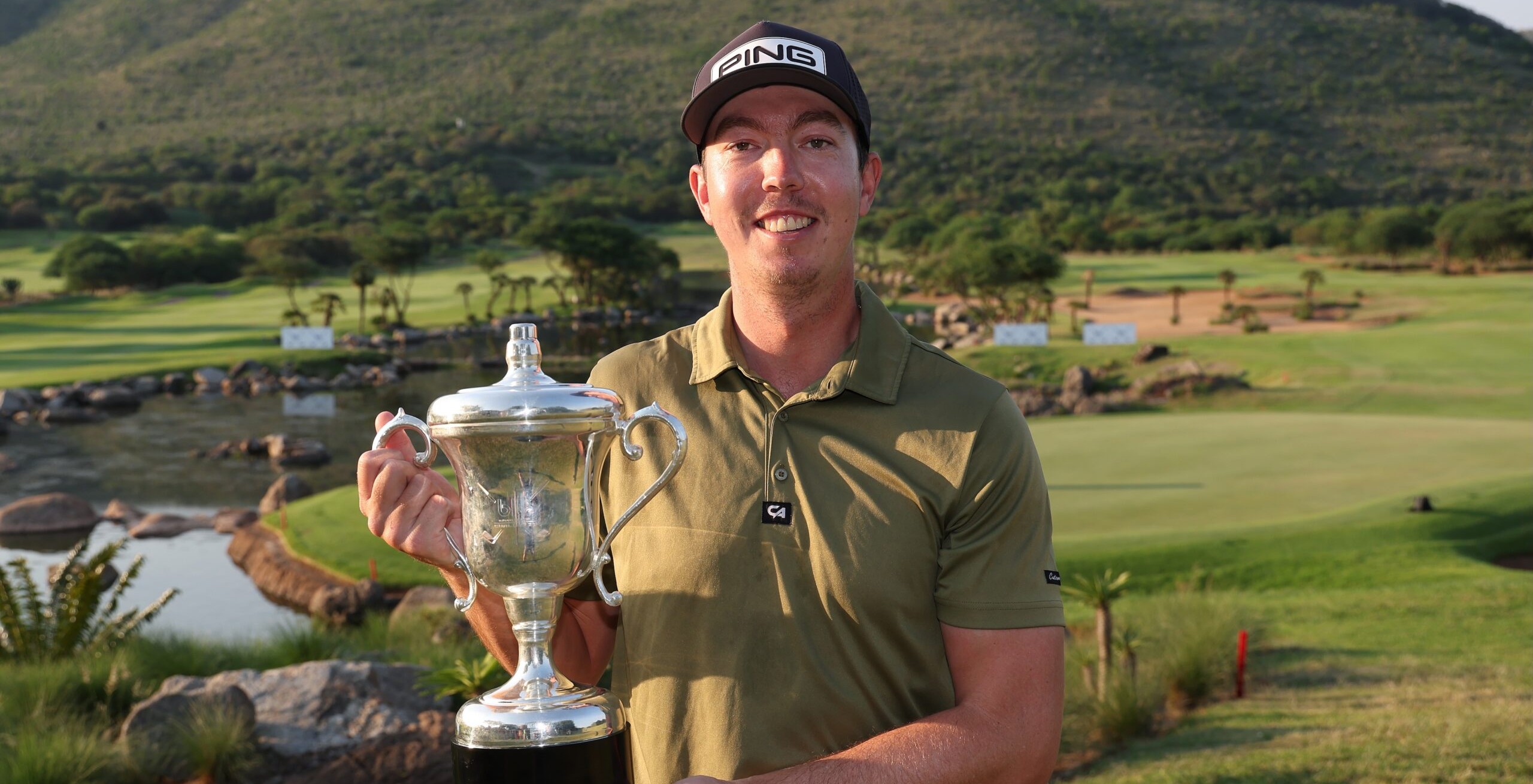 Luke Brown holding the Blu Label Unlimited Challenge trophy